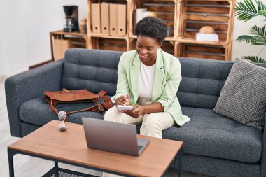 Afrika kökenli Amerikalı kadın psikolog, psikoloji merkezindeki kanepede oturuyor.