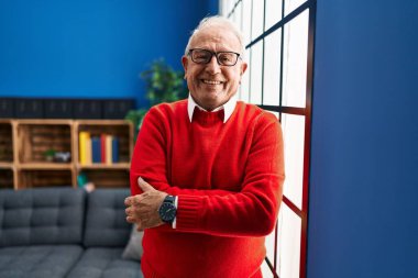 Senior man smiling confident standing with arms crossed gesture at home