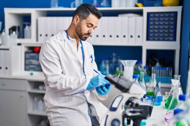 Laboratuvarda panoya yazı yazan genç İspanyol bilim adamı.