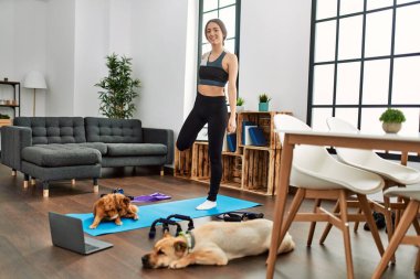 Evde esneme kursu aldığından emin bir şekilde gülümseyen genç İspanyol kadın.