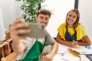 Genç İspanyol sanatçı çift resim stüdyosunun önünde mutlu bir şekilde selfie çekiyor..