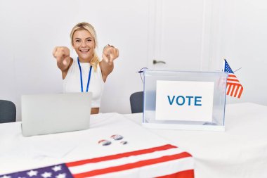 Young caucasian woman at america political campaign election pointing to you and the camera with fingers, smiling positive and cheerful 