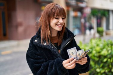 Sokakta dolar sayarak kendine güvenen genç bir kadın.
