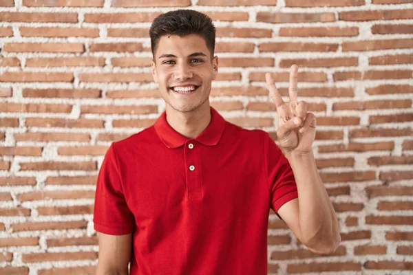 Young Hispanic Man Standing Bricks Wall Showing Pointing Fingers Number — Photo
