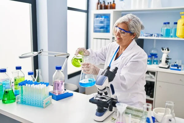 Middle Age Woman Wearing Scientist Uniform Pouring Liquid Test Tube — Foto Stock