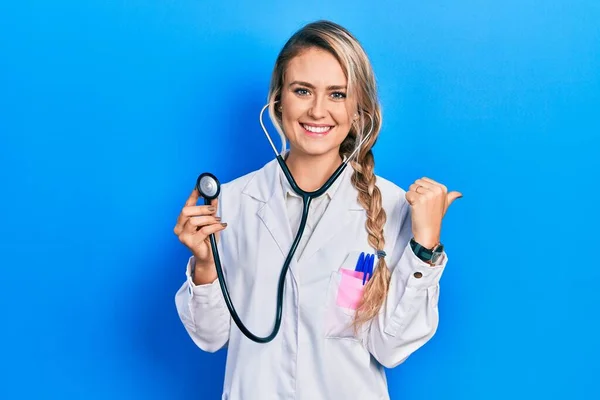 Beautiful Young Blonde Doctor Woman Holding Stethoscope Pointing Back Hand — Stok fotoğraf