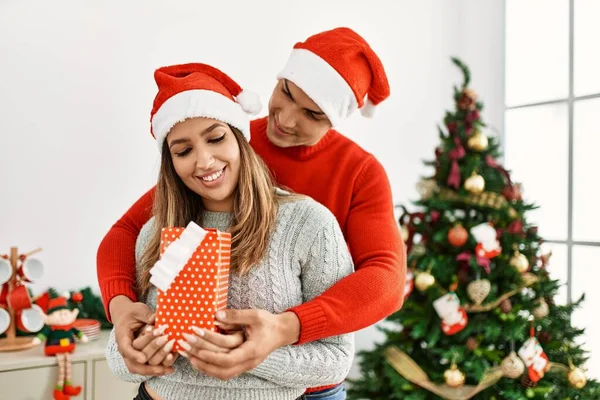 Fiatal Pár Boldogan Ölelkezik Mosolyog Karácsonyi Kalapot Visel Ajándékot Tart — Stock Fotó
