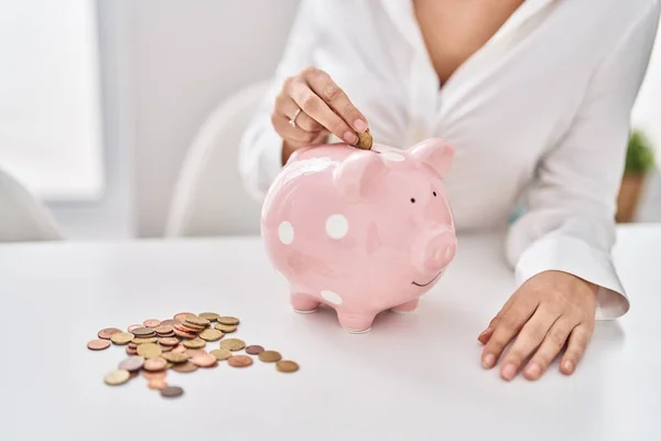 Jovem Mulher Inserindo Moeda Banco Porquinho Casa — Fotografia de Stock