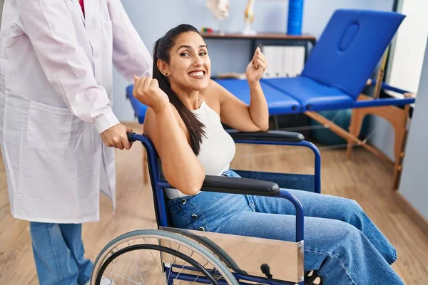 Young Hispanic Woman Sitting Wheelchair Physiotherapy Clinic Screaming Proud Celebrating — Stock Photo, Image