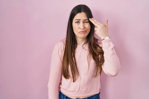 Joven Morena Pie Sobre Fondo Rosa Disparando Matándose Señalando Mano —  Fotos de Stock