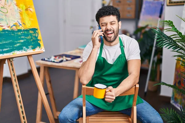 Νεαρός Άραβας Καλλιτέχνης Μιλάει Στο Smartphone Πίνοντας Καφέ Στο Στούντιο — Φωτογραφία Αρχείου