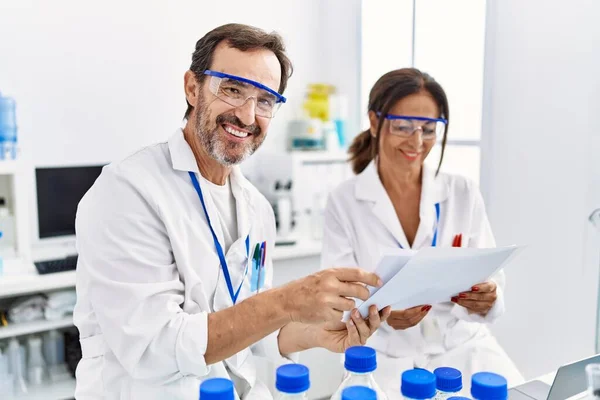 Middle Age Man Woman Partners Wearing Scientist Uniform Reading Document — Stock Photo, Image