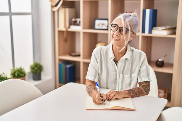 Middle Age Grey Haired Woman Writing Notebook Sitting Table Home — Stockfoto
