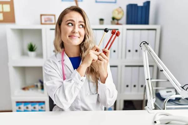 Young Beautiful Doctor Woman Holding Diapason Instrument Smiling Looking Side — Fotografia de Stock