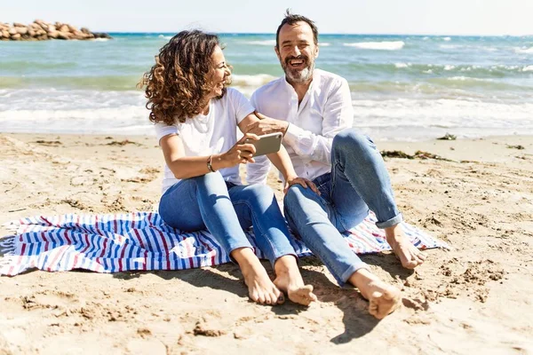 Middle Age Hispanic Couple Using Smartphone Sitting Towel Beach — Stock Photo, Image
