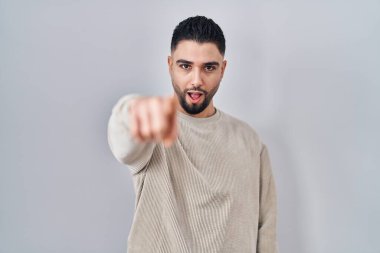 Genç yakışıklı adam izole edilmiş arka planda dikiliyor. Kameraya kızgın ve sinirli olduğunu gösteriyor. 
