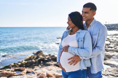 Genç, Latin bir çift bebek bekliyor. Birbirlerine sarılıyorlar.