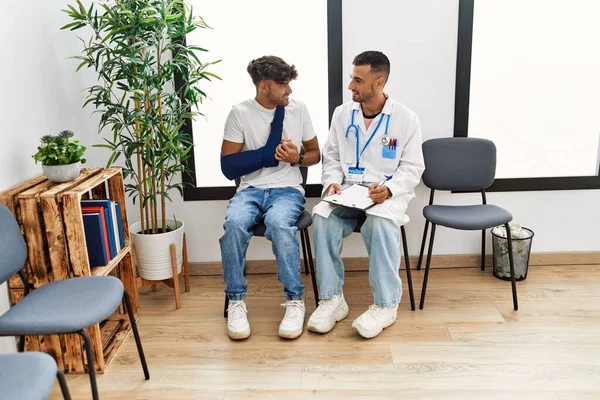 Två Latinamerikanska Män Läkare Och Patient Skriver Urklipp Sitter Stol — Stockfoto