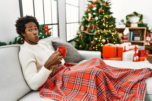 Joven Afroamericano Sentado Sofá Bebiendo Café Junto Árbol Navidad Haciendo — Foto de Stock