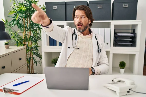 Handsome Middle Age Doctor Man Working Clinic Pointing Finger Surprised — Foto de Stock