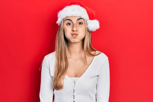 Noel Şapkası Takan Güzel Spanyol Kadın Komik Yüzlü Yanakları Şişiriyor — Stok fotoğraf
