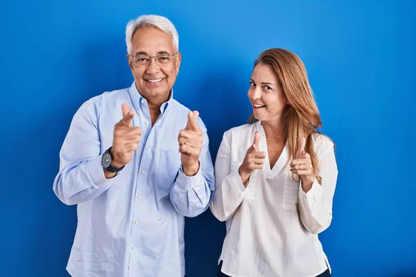 Middle Age Hispanic Couple Standing Blue Background Pointing Fingers Camera — kuvapankkivalokuva