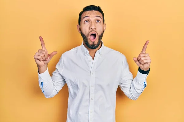 Hispanic Man Beard Wearing Business Shirt Amazed Surprised Looking Pointing — Zdjęcie stockowe