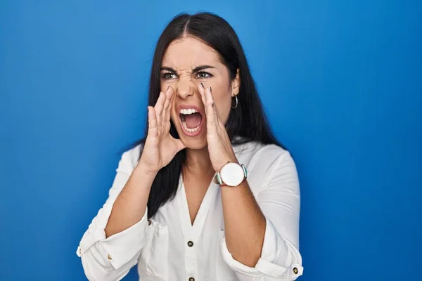 Junge Hispanische Frau Steht Vor Blauem Hintergrund Und Schreit Wütend — Stockfoto