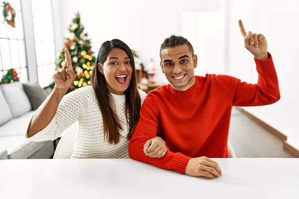 Jong Latijn Paar Zitten Tafel Door Kerstboom Glimlachend Verbaasd Verrast — Stockfoto