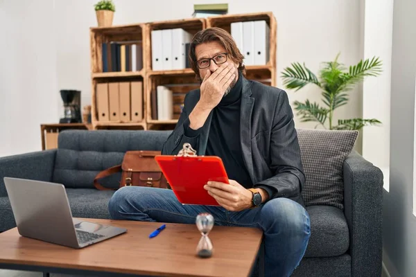 Handsome Middle Age Man Working Consultation Office Shocked Covering Mouth — Stockfoto