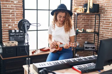 Genç, güzel, İspanyol bir müzisyen müzik stüdyosunda klasik gitar çalıyor.