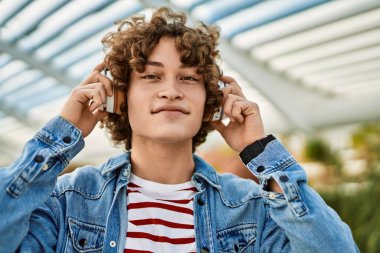 Şehirde kulaklık takıp müzik dinleyen genç bir İspanyol.