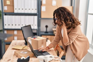 Middle age hispanic woman working speaking on the phone at ecommerce