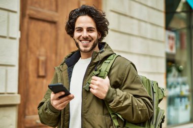 Şehirde akıllı telefon kullanan yakışıklı bir İspanyol.