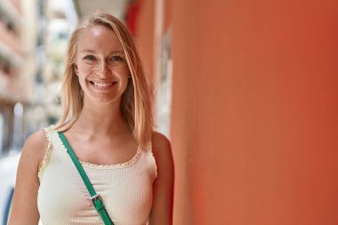 Sokakta kendine güvenen genç sarışın kadın gülümsüyor