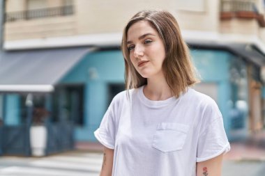 Sokakta duran rahat yüzlü genç kadın.