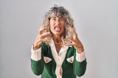 Orta yaşlı bir kadın öfkeden kudurmuş, elleri boğazlamaya çalışıyor, deli gibi bağırıyor. 