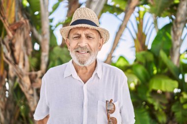Senior man smiling confident wearing summer hat at park