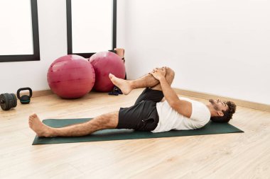 Genç İspanyol adam gülümsüyor spor merkezinde esniyor.