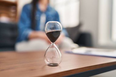 Young beautiful hispanic woman patient having mental therapy sitting on sofa at psychology clinic