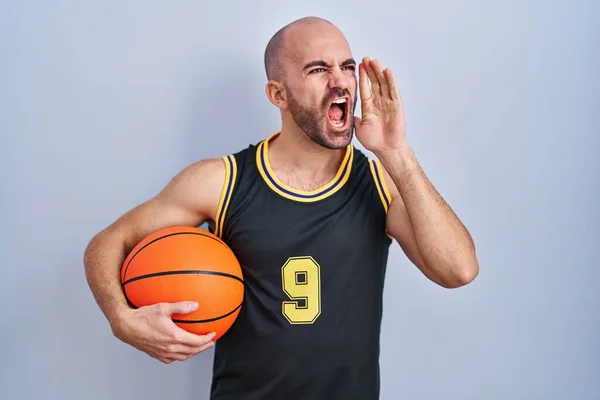 Mladý Plešatý Muž Vousy Basketbalové Uniformě Držící Míč Křičící Křičící — Stock fotografie
