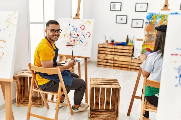 他的年轻夫妇在艺术工作室高兴地微笑着画画 — 图库照片
