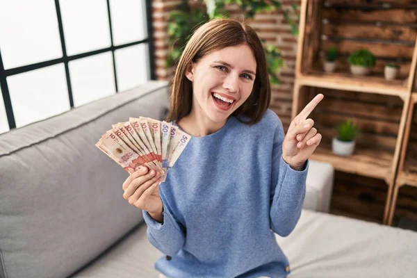 Joven Morena Sosteniendo Pesos Colombianos Sonriendo Feliz Señalando Con Mano — Foto de Stock