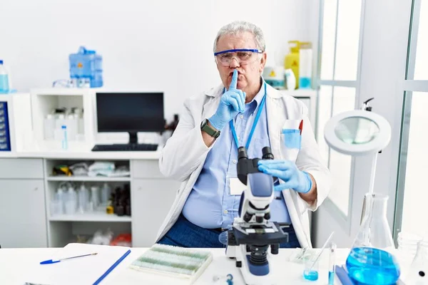 Starszy Biały Mężczyzna Pracujący Laboratorium Naukowym Proszący Ciszę Palcem Ustach — Zdjęcie stockowe