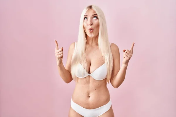 Caucasian Woman Wearing Lingerie Pink Background Amazed Surprised Looking Pointing — Foto de Stock