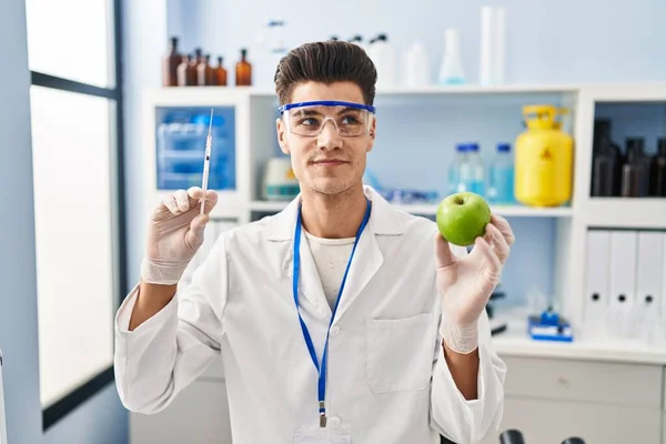 Young Hispanic Man Working Scientist Laboratory Holding Apple Smiling Looking — Stock fotografie