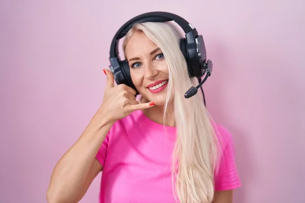Caucasian Woman Listening Music Using Headphones Smiling Doing Phone Gesture — Stock fotografie