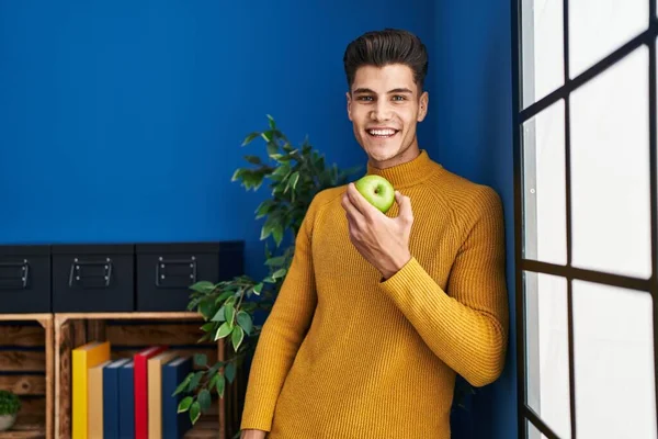 Młody Latynos Uśmiecha Się Pewnie Jedząc Jabłko Domu — Zdjęcie stockowe