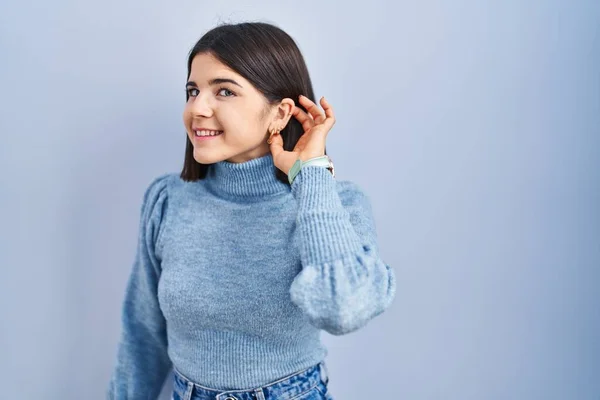 Young Hispanic Woman Standing Blue Background Smiling Hand Ear Listening — Stok fotoğraf