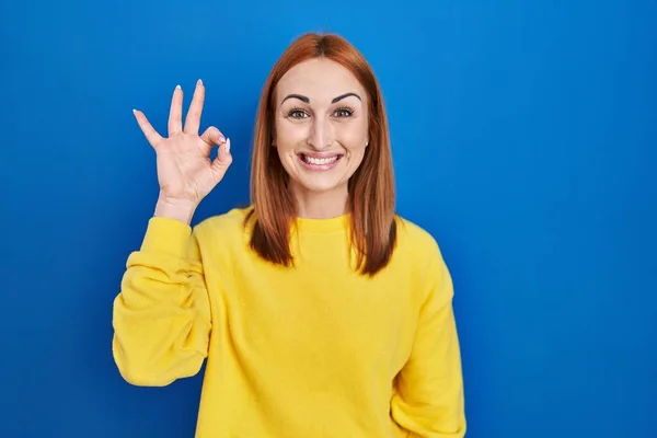 Mujer Joven Pie Sobre Fondo Azul Sonriendo Positiva Haciendo Signo —  Fotos de Stock